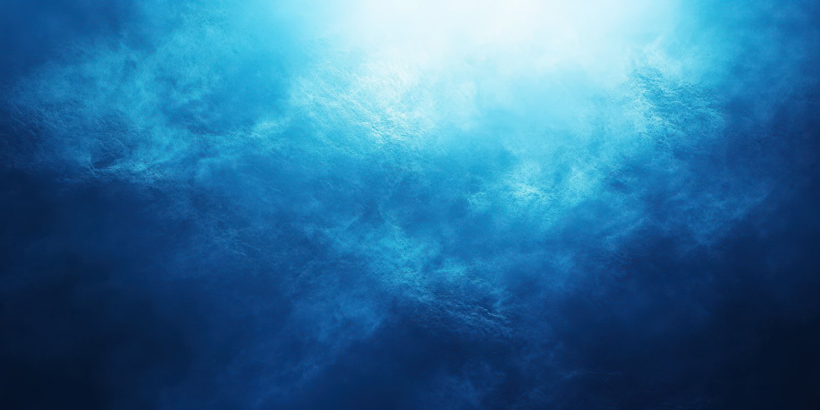 Light filters through ocean water creating an ethereal blue atmosphere in the deep sea